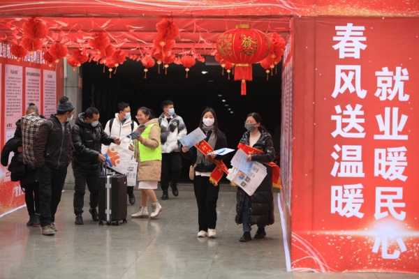 工作人员在火车站为返乡人员宣传就业政策。秀山县委宣传部供图