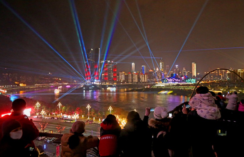 1月19日晚，南岸区长嘉汇，市民在观看灯光表演试灯。