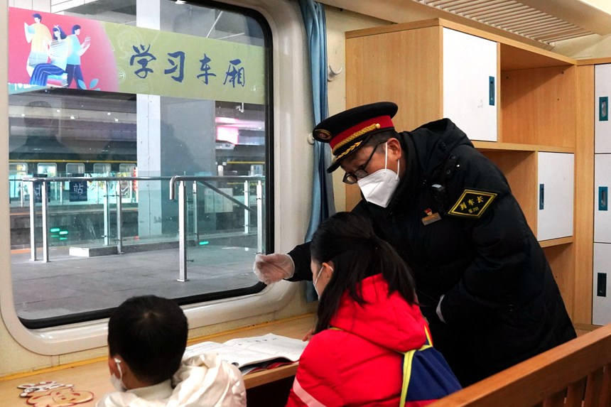 在5609次列车上，列车长王友为乘车的小学生讲解车内服务设备。罗希雅摄