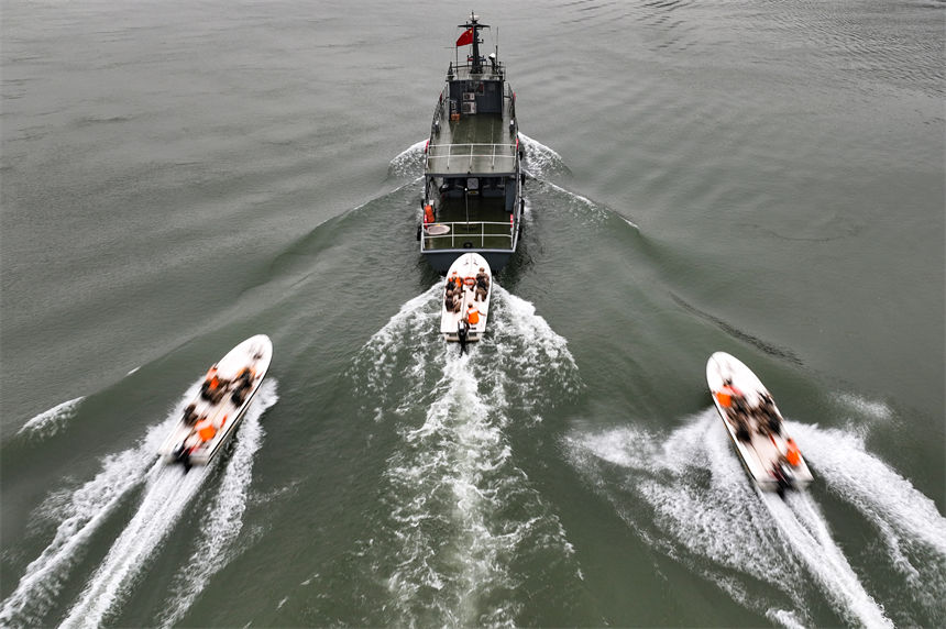 武警官兵乘坐冲锋舟对目标船只进行追击。曹洋摄（无人机画面）