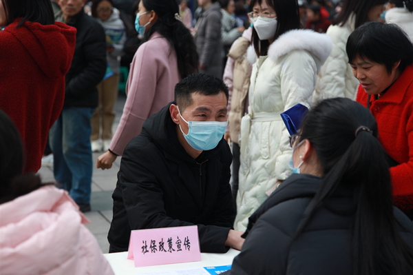 工作人员向市民宣传社保政策。李波摄