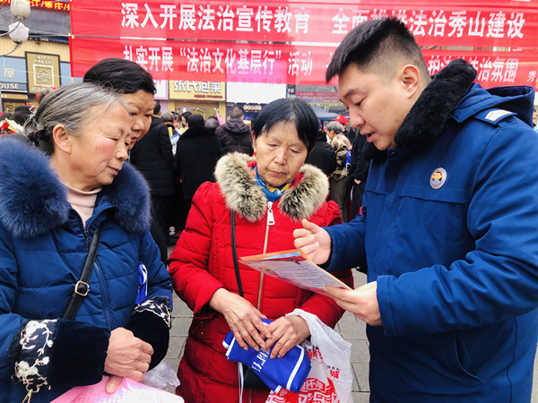 秀山县消防救援大队宣传员田涛（右一）正为市民宣传消防安全知识。杨帆摄