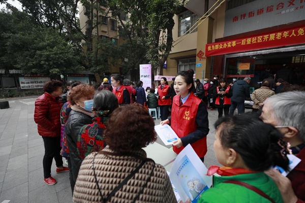 3月2日，在重庆市南岸区后堡社区，该区税务人员为社区居民讲解灵活就业人员社保费政策和手机缴费流程。蒋宜非摄