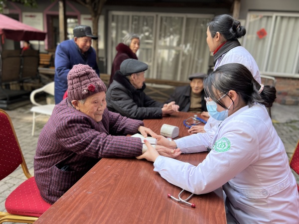 志愿者帮老人们义诊。陈湘琳摄