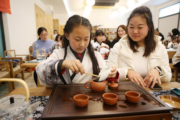 学生和家长体验泡茶技艺。杨敏摄
