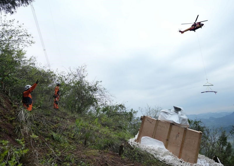 直升机在山地间开展物资吊装作业。李涛摄