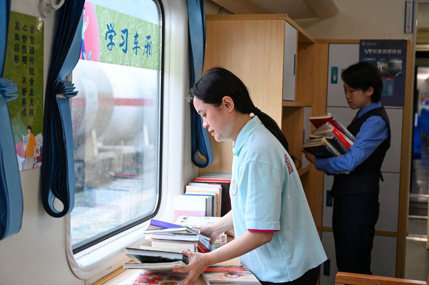 重庆客运段、重庆图书馆的志愿者们正在对列车书屋的图书做最后的调整。钟洁摄