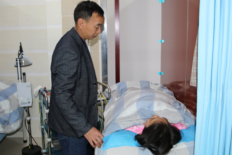 楊前海陪妻子陳長軒在中醫院接受理療。楊夏麟攝