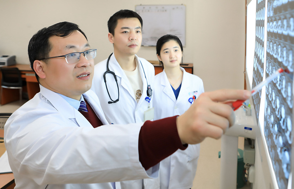 胸心外科主任医师李洪波（左一）与团队研究患儿CT。重医附属儿童医院供图