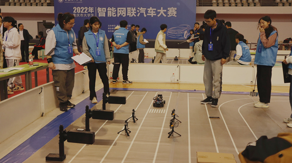 重慶理工大學參賽隊伍的智能網聯模型車在環線曲線賽道上比賽。晏紅霞攝