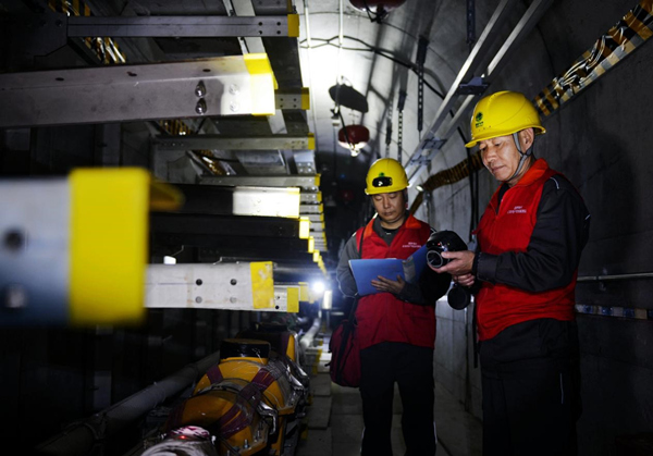 國家電網紅岩（市區輸電）共產黨員服務隊隊員在解放碑環形電力隧道開展特巡測溫工作。韓薇攝