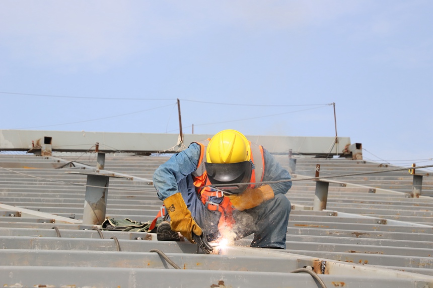 4月29日，工作人員在重慶江北國際機場T3B航站樓施工現場進行屋面施工。中建八局供圖