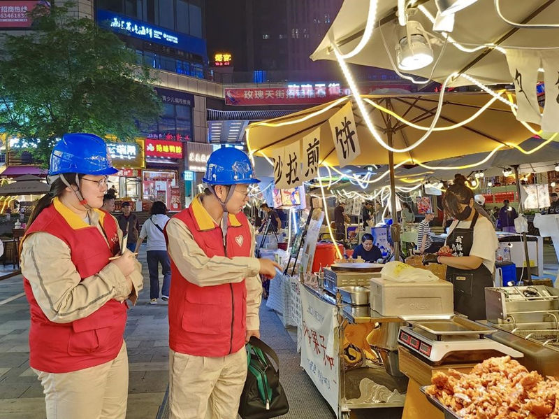4月29日，国网重庆市北供电公司员工在渝北区爱情海购物中心烟火集市进行用电安全夜间巡视。钟雪摄