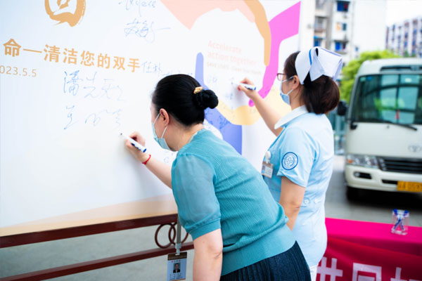 居民与医务人员共同在承诺墙上签下自己的名字。重庆医药高专附一院供图