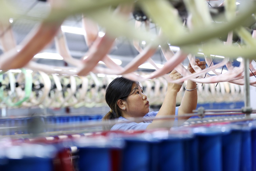 絲綢紡織女工在生產車間忙碌。楊敏攝
