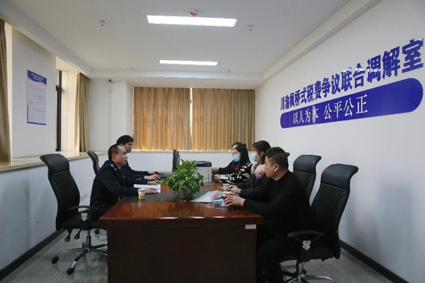 在荣昌区税务局的川渝枫桥式税费争议联合调解室，税务人员正了解企业诉求。文明燕摄