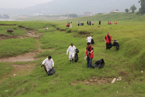 志愿者们在长江岸边清理垃圾。美心红酒小镇供图