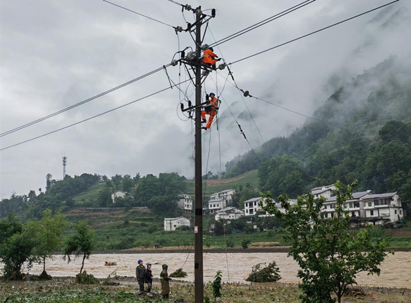 應急搶修隊在坪壩鎮瓦房村對10千伏坪岔線18號杆的引流線進行改接。國網重慶城口供電公司供圖