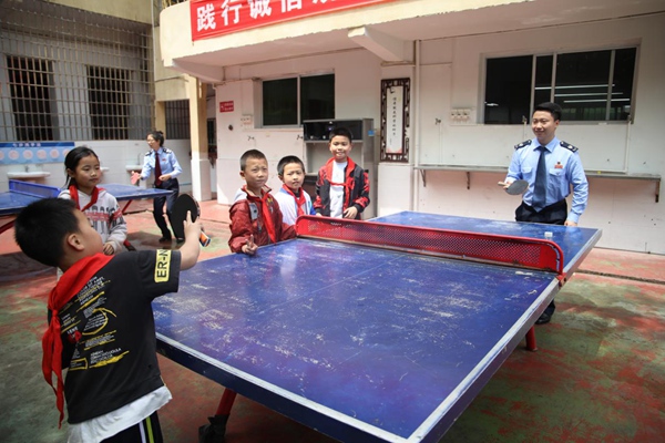 在豐都縣仁沙鎮中心小學校，該縣稅務人員與小朋友們利用課間一起打乒乓球。張凌雲攝