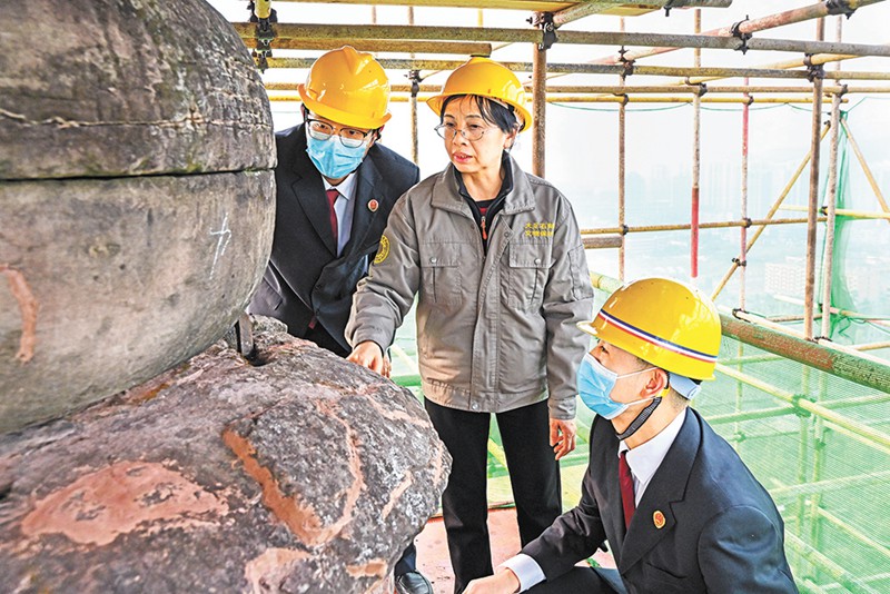 大足石刻研究院文物保护专家正在开展南塔修复工作。（大足区检察院吴杰摄）