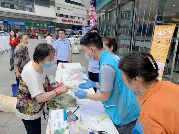 檢驗機構人員為市民送檢的蔬菜開展快速檢測。重慶市市場監管局供圖