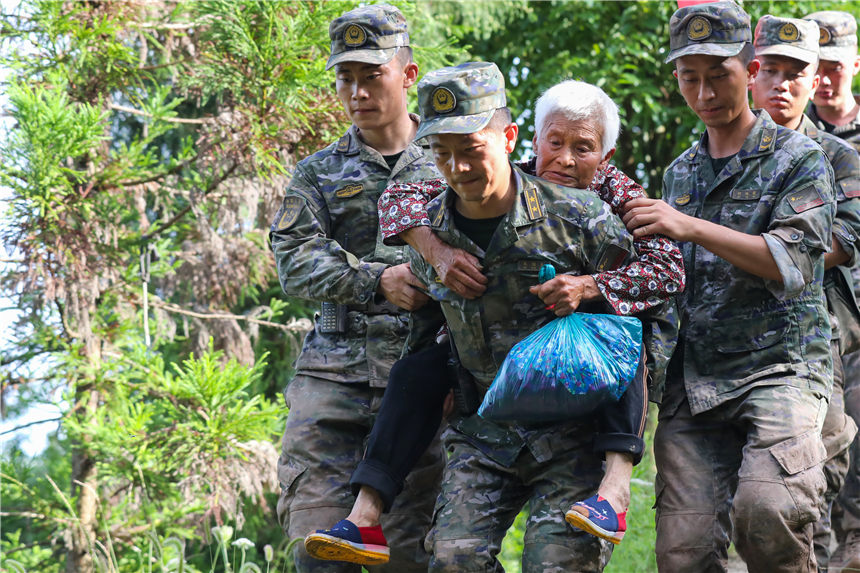 武警官兵轉移被困群眾。李東攝