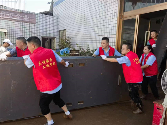 雷锋的士志愿者参与现场救灾，帮助商户搬运设备。万州区委宣传部供图 华龙网发