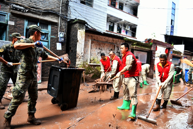 7月7日，國家電網紅岩（萬州營配）共產黨員服務隊與武警官兵同心協力清淤。王倩攝