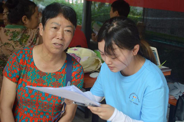 志愿者向村民普及反诈知识。重庆财经学院供图