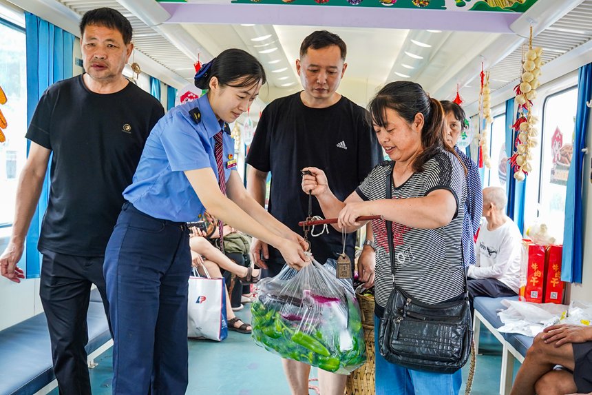 7月11日，5630次列车上，列车志愿者帮助旅客售卖农产品。李文航摄