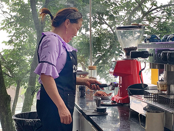 53岁的乡村咖啡师冉光芳正在为游客制作咖啡。许琳珮摄