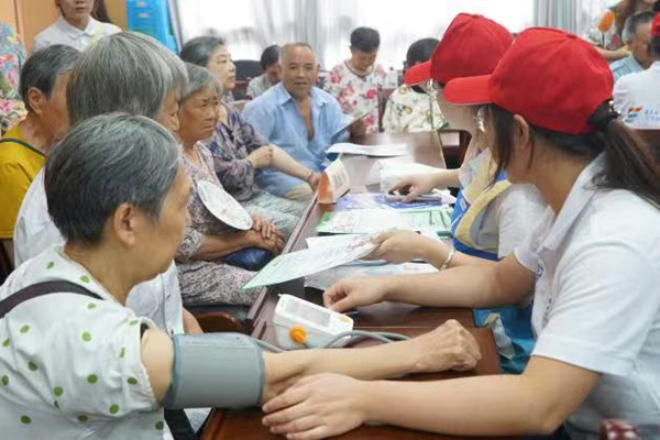 志愿者为老年人检查身体。重庆电子工程职业学院供图