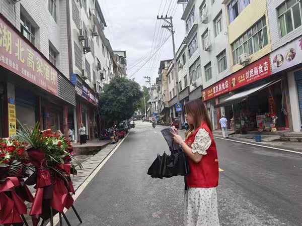 云阳县红狮镇咏梧社区专职网格员走访辖区商铺。王鑫文摄