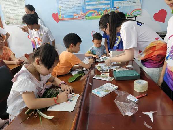 重庆大学经济与工商管理学院实践团指导小朋友制作植物拓染环保布袋。李华摄