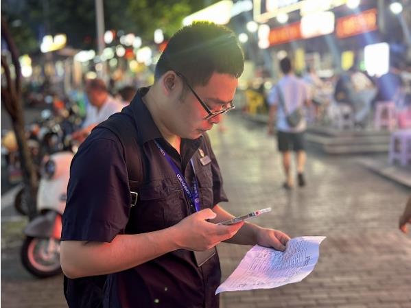 重庆燃气集团沙坪坝分公司工作人员邱韬铭正在路灯下核实非居民客户信息。重庆燃气集团供图
