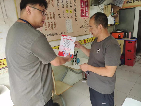 社区工作人员张贴液化气罐两单两卡。虎中社区供图