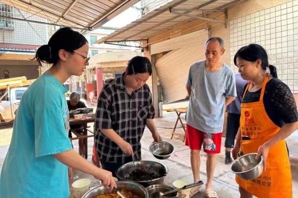 赵英洁（左二）、赵彬洁（左一）姐妹正在忙着分装热菜。潼南区委宣传部供图