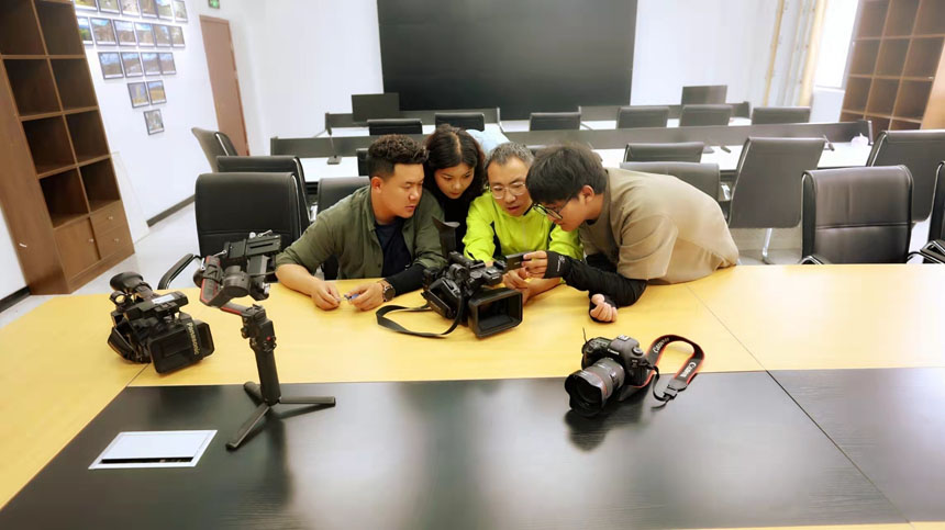 李彬（右二）与年轻采编人员交流技术。察雅县融媒体中心供图