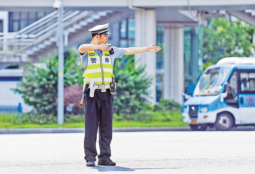 8月11日，江北区金源路，江北区公安分局交巡警支队民警杨尚峰正头顶烈日在路口指挥交通。记者 齐岚森 摄/视觉重庆