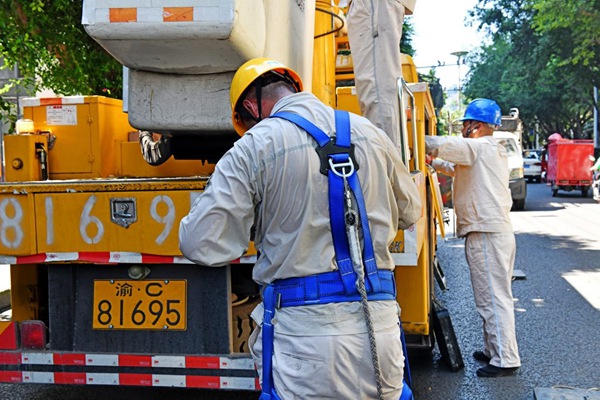 8月15日，在合川區振興路，帶電作業人員結束工作后解下裝備，作業服已濕透。高愛妮攝