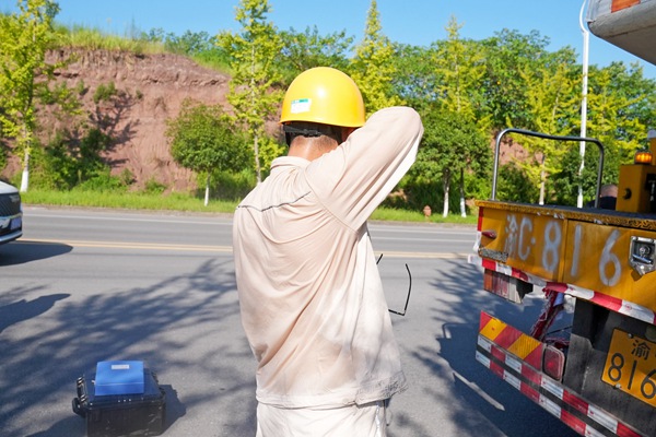 8月15日，在合川區工業園區，帶電作業人員完成作業后擦拭汗水。高愛妮攝