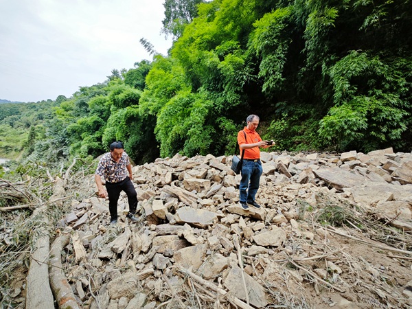 《逆行的抢险救灾地质人》。7月6日，南江地质专家黄永泽（右）、陈亮及当地人员在万州长滩镇沙滩村幺磨坪滑坡抢险救灾路上，道路中断，从杂草丛和滑坡堆积体上绕行。廖学海摄