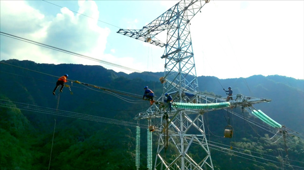 國網重慶市電力公司員工在蟠龍抽水蓄能電站500千伏送出工程現場開展高空施工作業。韓俊攝