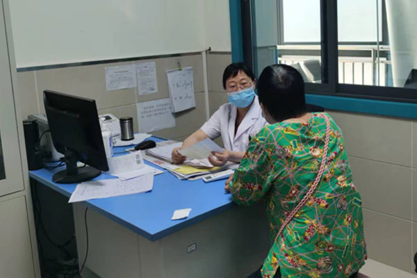 董世庆在门诊处接受患者咨询。重庆市红十字会医院（江北区人民医院）供图
