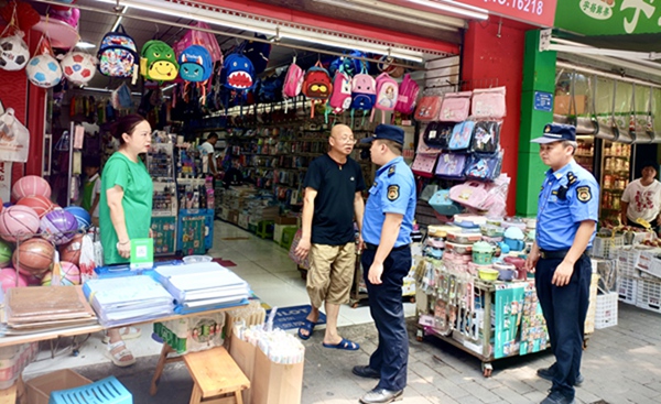 城管执法人员巡查校园周边，督促商家整改店外经营 。巴南区城管局供图
