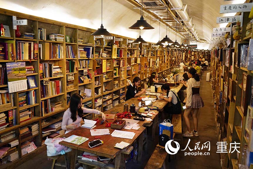 书架沿洞壁摆放，市民游客正在看书学习。  人民网记者 刘祎摄