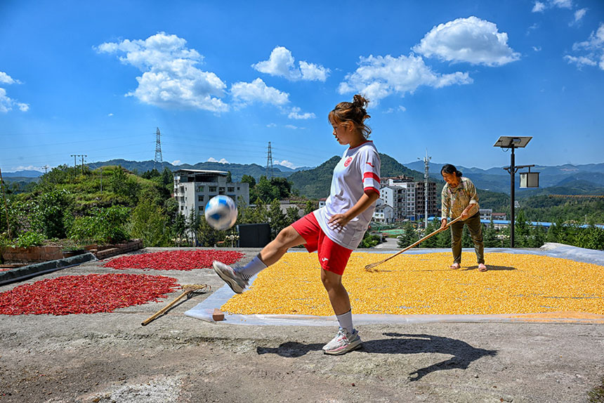 8月31日,石柱县三河镇,马诗彤帮助奶奶干农活的间隙在院坝里练习颠球。