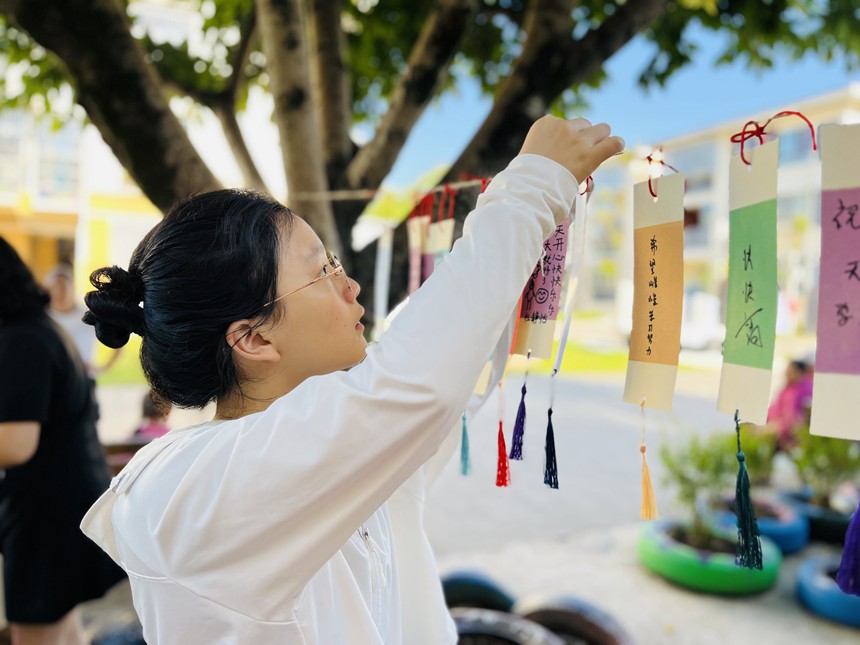 在梁平区实验幼儿园物流园区，家长为小朋友悬挂“爱的书签”。