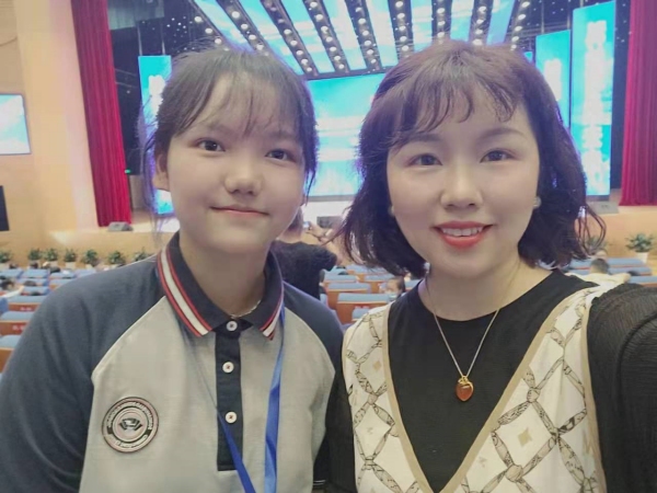 2021年郑霞飞（右）带队何渝杰（左）参加第36届重庆市青少年创新科技大赛。受访者供图