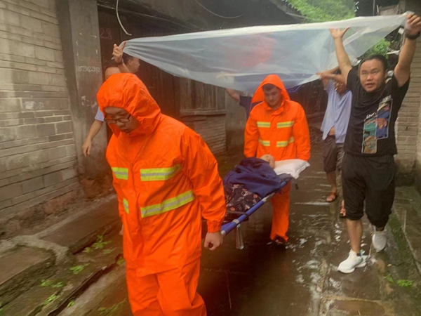 《紧急撤离》。8月2日强降雨之后，永川区松溉镇驻守地质工程师和镇政府工作人员在巡查时发现有居民房屋发生地面沉降、墙体开裂等问题，立即开展了11户受威胁群众的紧急撤离工作。图为工作人员正在帮助行动不便的老人转移到安全地带。  罗庆伟摄